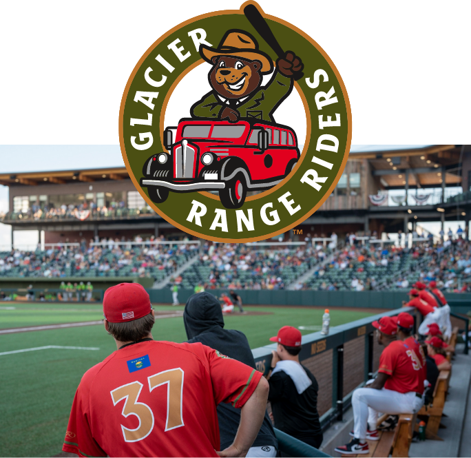 View from the Glacier Range Riders dugout looking toward the third baseline building with the Huck primary logo for the team